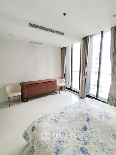 Spacious bedroom with large windows and elegant decor in modern apartment