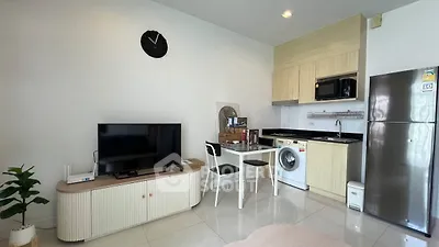 Modern living room with kitchen, TV, washing machine, and sleek furniture