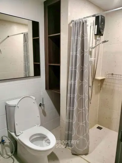 Modern bathroom with shower curtain and toilet in sleek apartment