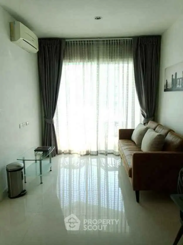 Modern living room with sleek design, featuring a cozy sofa and large window for natural light.
