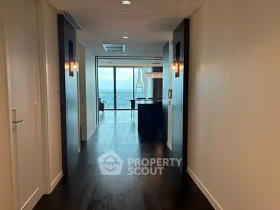 Luxurious hallway leading to a stunning ocean view living area with modern decor.