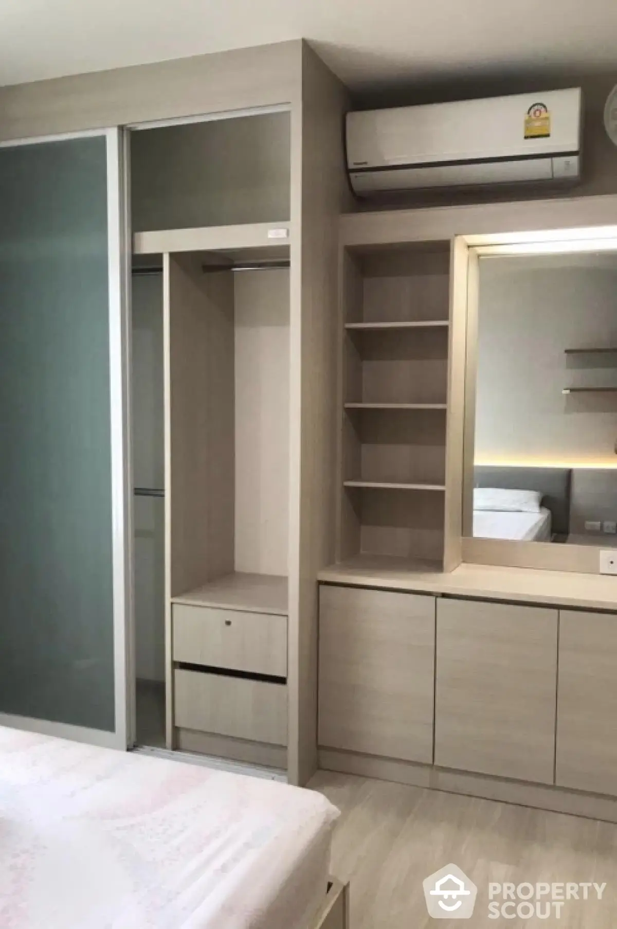 Modern bedroom with built-in wardrobe and air conditioning unit