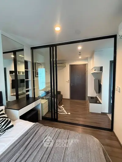 Modern bedroom with glass partition and stylish decor in a contemporary apartment.