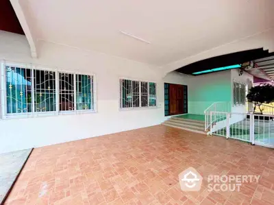 Spacious covered patio with tiled flooring and secure window grills in a modern home.