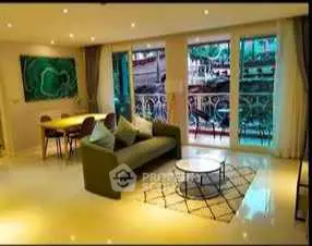 Spacious living room with elegant decor and large windows offering a vibrant view.