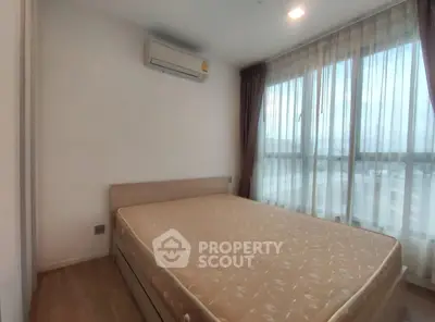 Modern bedroom with large windows and air conditioning in a bright apartment.