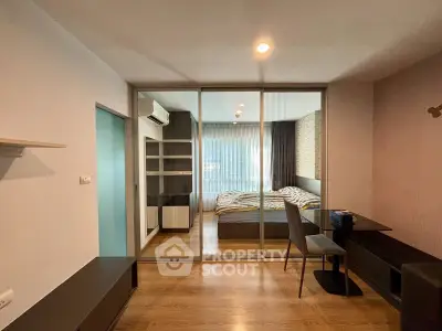 Modern studio apartment with glass partition, cozy bedroom, and stylish living area.