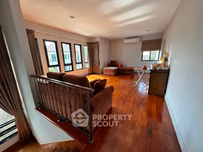 Spacious living room with hardwood floors and large windows offering natural light.