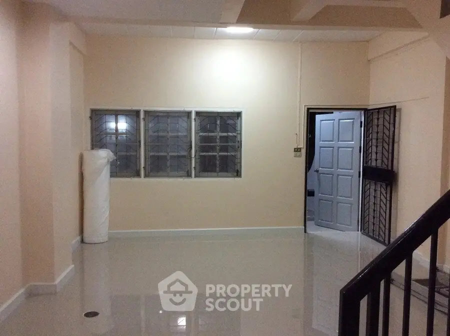Spacious unfurnished room with glossy tiled floor and secure window bars