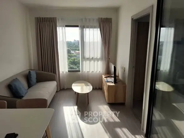 Bright and cozy living room with modern furniture and large window view.