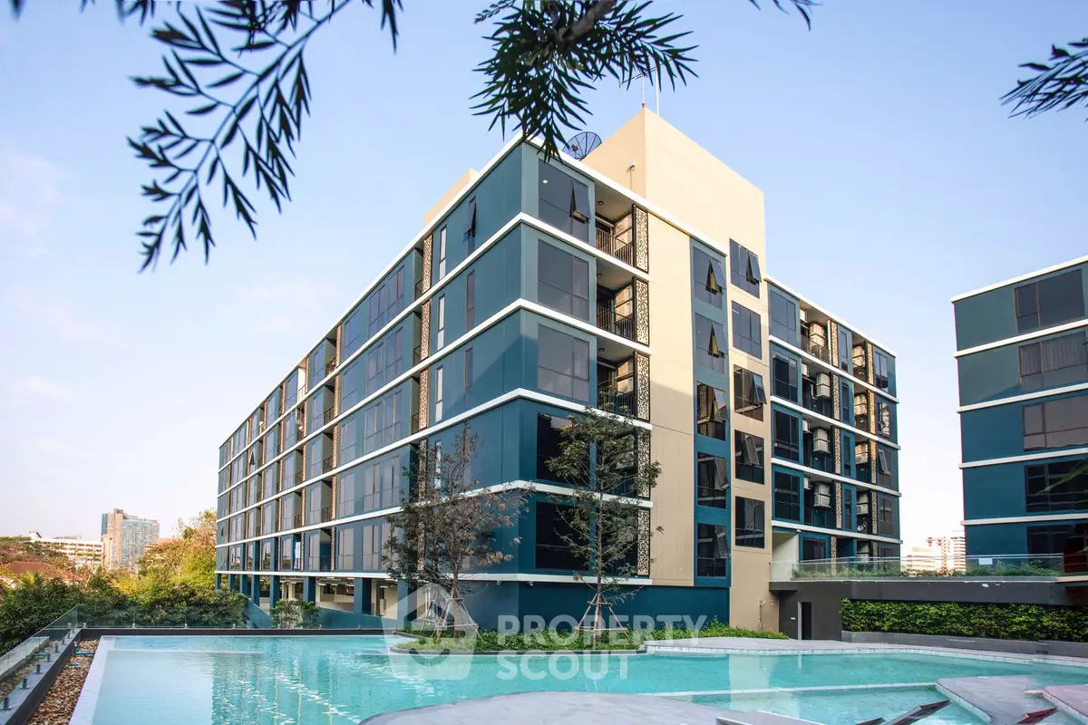 Modern apartment building with a luxurious pool and lush greenery