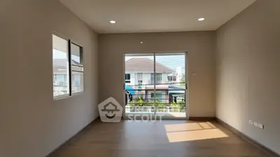 Spacious empty room with large windows and balcony access in modern home