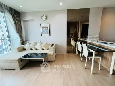 Modern living room with open kitchen, stylish decor, and natural light