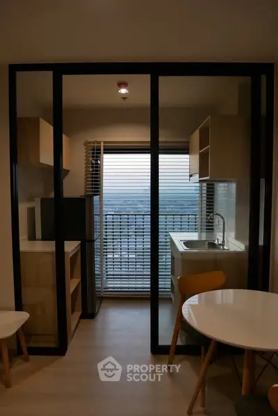 Modern compact kitchen with balcony view in stylish apartment