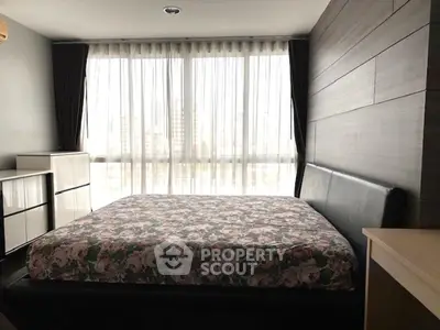 Spacious bedroom with large windows and modern decor in urban apartment