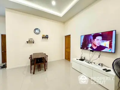 Modern living room with wall-mounted TV and dining table in stylish apartment.