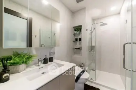 Modern bathroom with sleek shower and elegant vanity in contemporary home.
