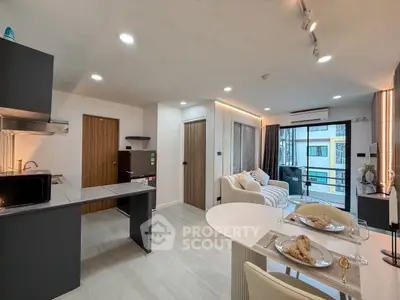 Modern open-plan living room and kitchen with stylish decor and natural light