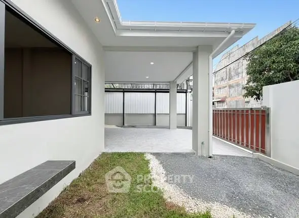 Modern exterior view of a house with spacious driveway and covered parking area.
