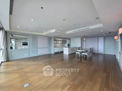 Spacious open-plan living and dining area with elegant wooden flooring and modern decor.