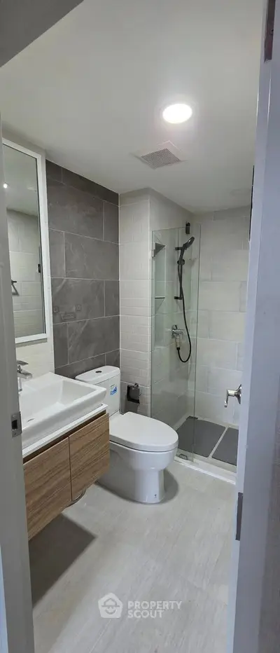 Modern bathroom with sleek design, featuring a glass shower, stylish sink, and contemporary fixtures.