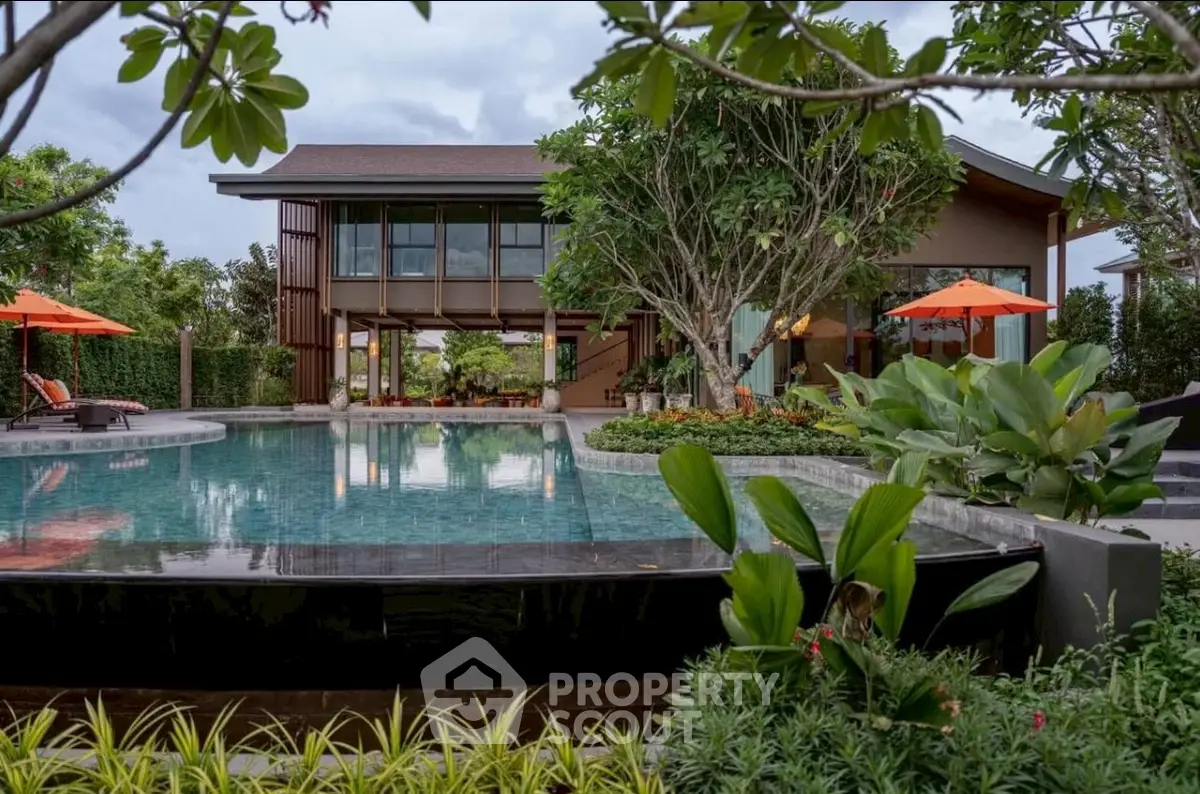Luxurious modern home with stunning pool and lush garden, perfect for relaxation and entertainment.