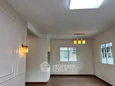 Spacious living room with modern lighting and large windows for natural light.