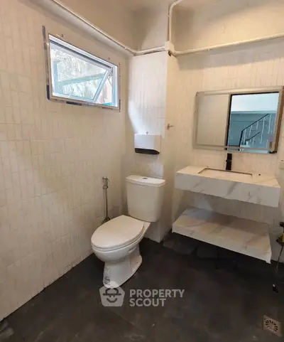 Modern bathroom with sleek fixtures and natural light, featuring a minimalist design and elegant tile work.