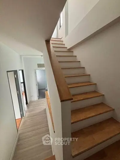 Modern staircase with wooden steps and sleek design in a contemporary home interior.