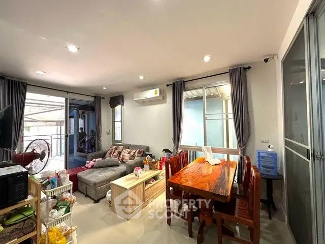 Cozy living room with dining area, featuring modern furniture and ample natural light.