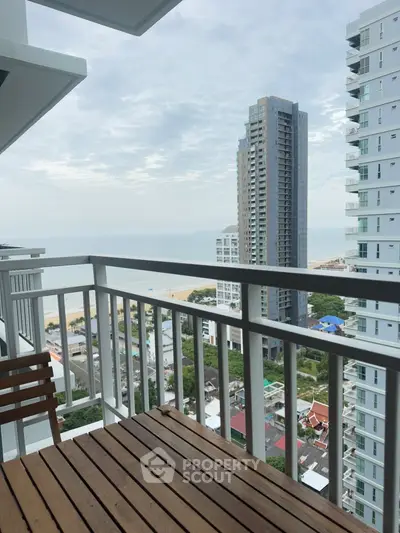 Stunning balcony view with ocean and cityscape, perfect for relaxation.