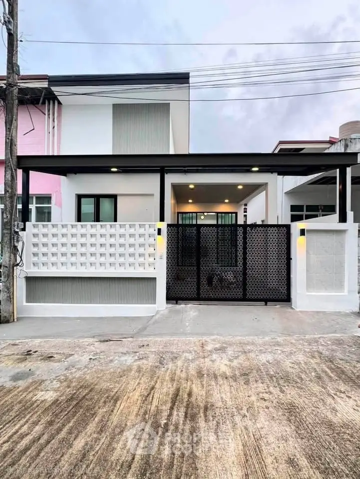 Modern two-story house with sleek facade and gated entrance, perfect for contemporary living.