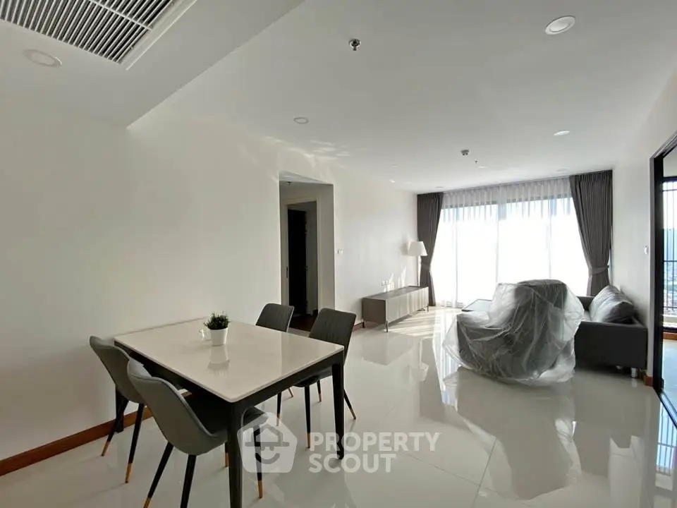 Spacious modern living room with dining area and large windows for natural light.