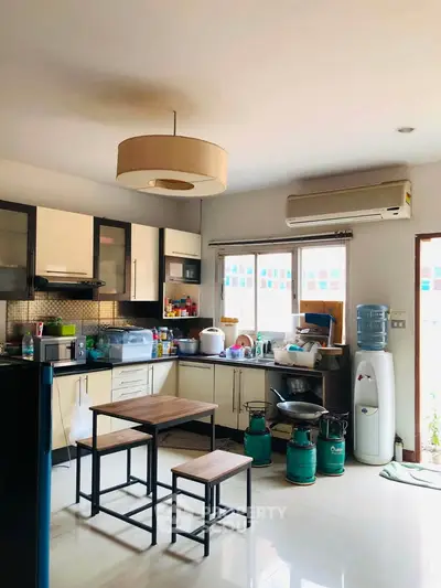 Spacious kitchen with modern appliances and dining area, featuring a gas stove and ample natural light.