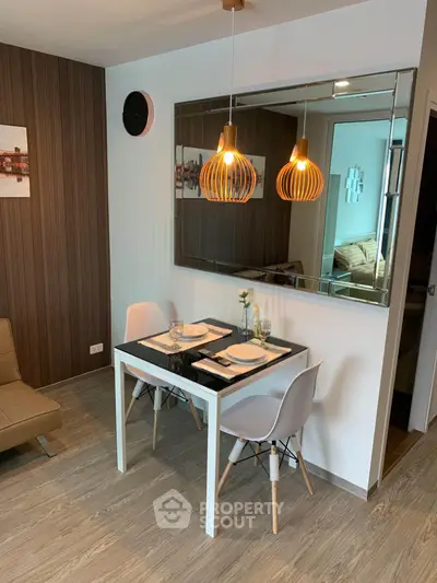 Modern dining area with stylish lighting and wooden accents in a cozy apartment.