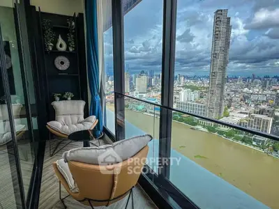 Stunning high-rise balcony view with cityscape and river, featuring cozy seating area.