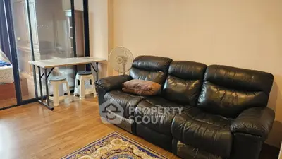 Cozy living room with leather sofa and wooden flooring in modern apartment