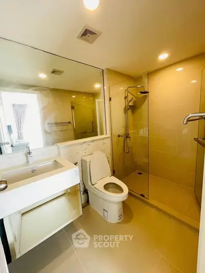 Modern bathroom with glass shower and sleek fixtures in a contemporary apartment.