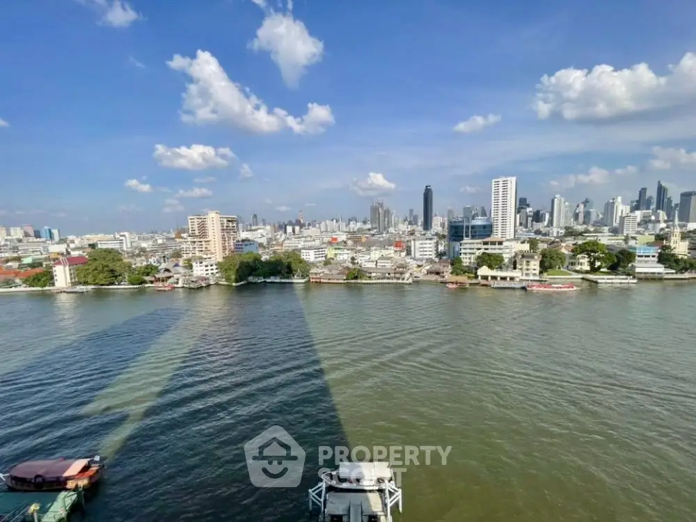 Stunning cityscape view over a river with modern skyline and clear blue sky.