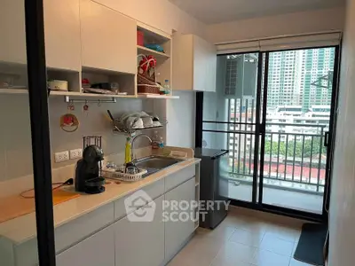 Modern kitchen with open layout and balcony view in urban apartment