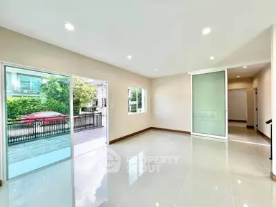 Spacious modern living room with large windows and glossy tile flooring
