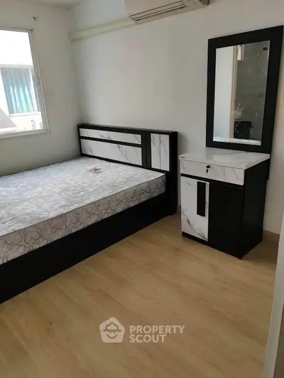 Modern bedroom with stylish bed and dresser, featuring elegant marble accents and natural light.