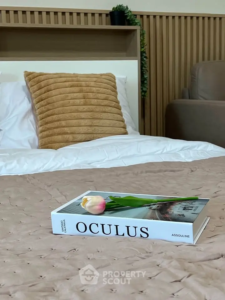 Cozy bedroom with stylish decor and a plush pillow, perfect for relaxation.