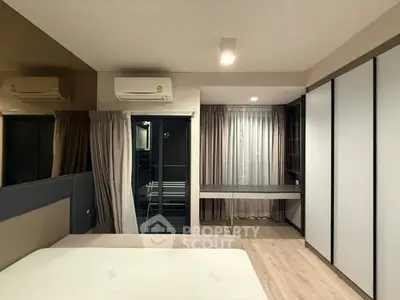 Modern bedroom with built-in wardrobe and air conditioning, featuring a sleek design and ample natural light.