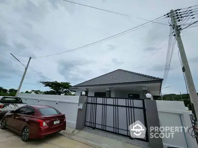 Modern single-story house with gated entrance and driveway parking