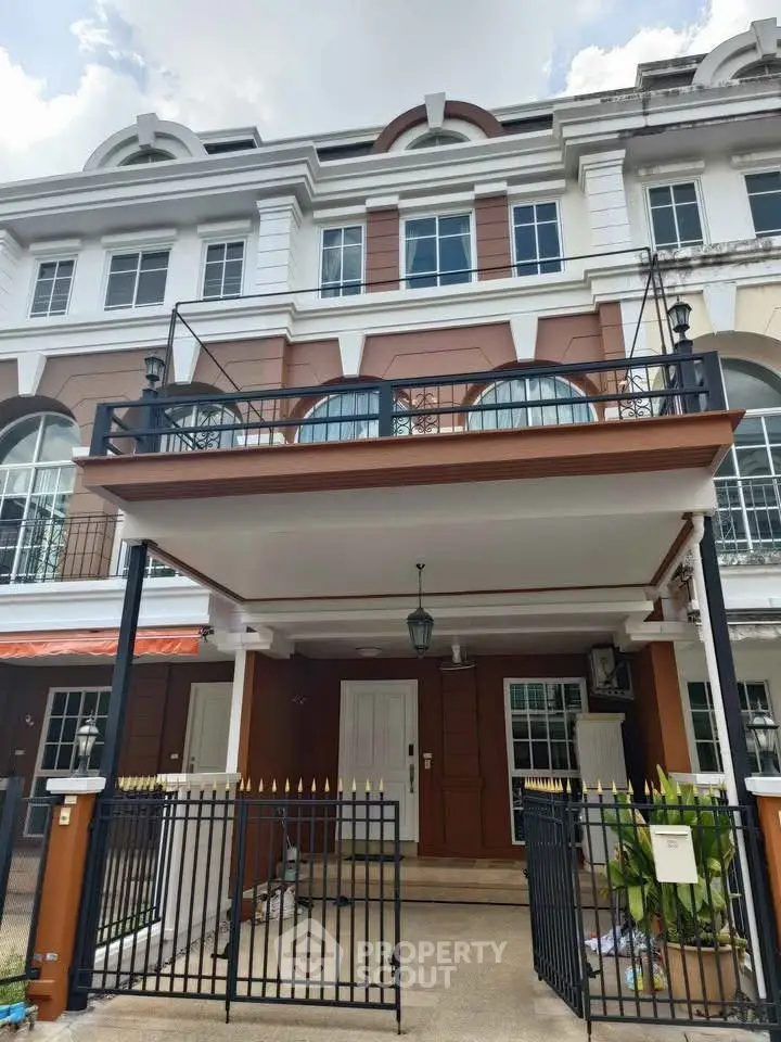 Charming multi-story townhouse with elegant facade and gated entrance