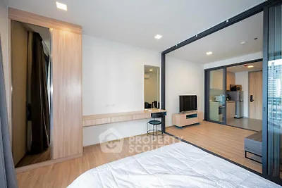 Modern open-plan apartment with spacious living area and stylish bedroom, featuring sleek wooden flooring and contemporary decor.