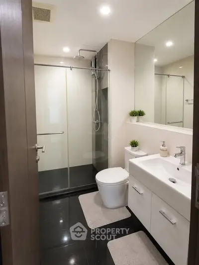 Modern bathroom with sleek fixtures and glass shower enclosure