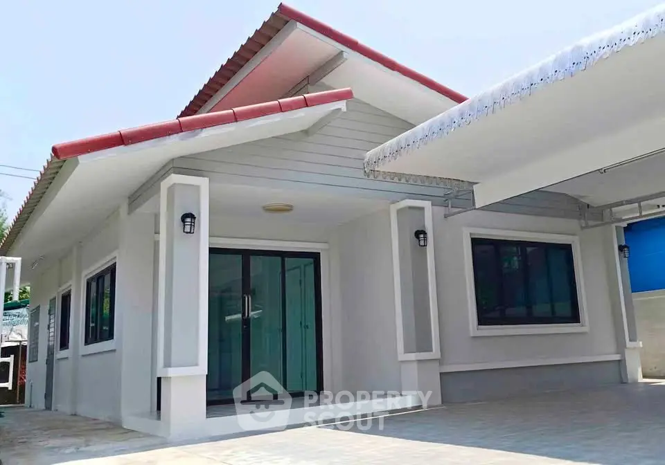 Charming single-story home with modern exterior and spacious driveway.