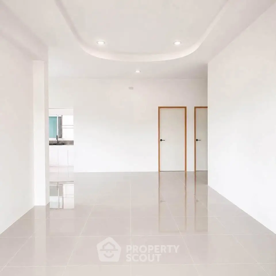 Spacious modern living room with glossy tiled floors and minimalist design.